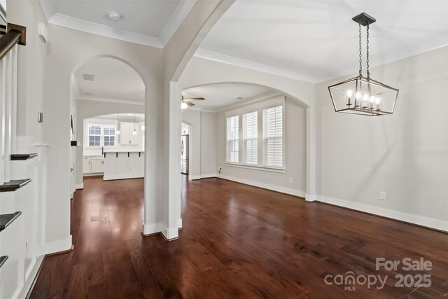 unfurnished dining area with ceiling fan, dark wood finished floors, ornamental molding, and a wealth of natural light