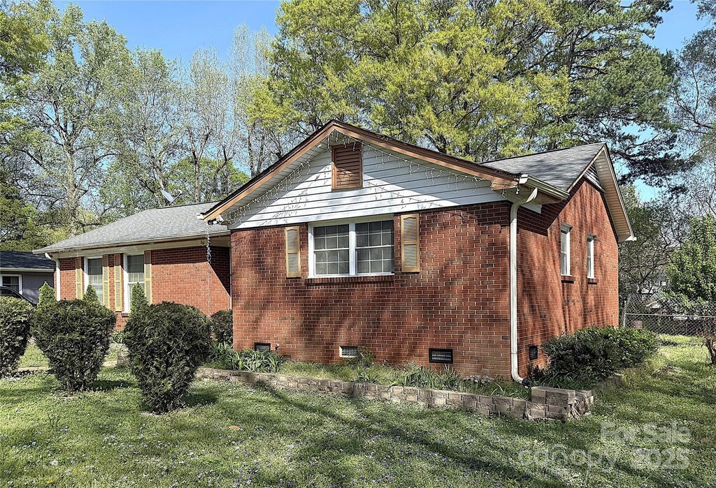 3220 Wiseman Dr, Charlotte, NC 28227 - view of side of home with a lawn, fence, and brick siding
