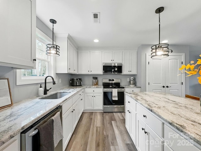 3018 Corinth Church Rd, Monroe, NC 28112 - kitchen with appliances with stainless steel finishes, a sink, white cabinetry, light wood-type flooring, and recessed lighting