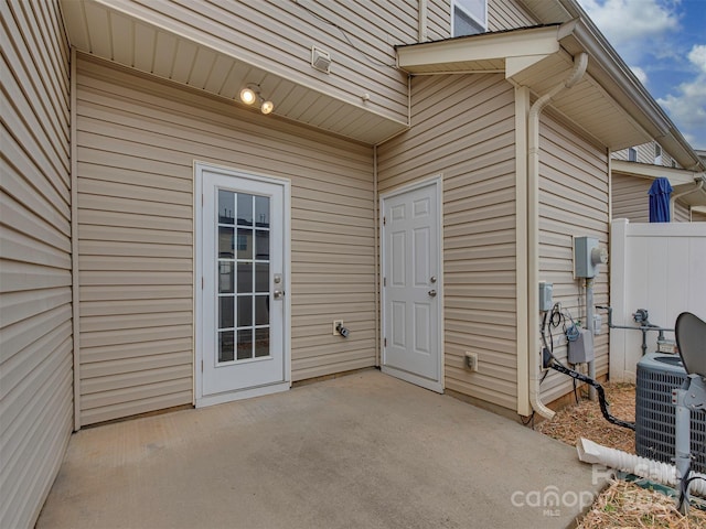 doorway to property featuring a patio area, central AC, and fence