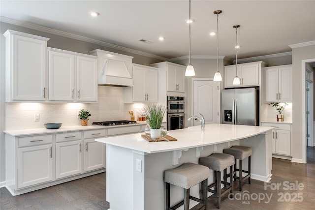 kitchen with visible vents, premium range hood, white cabinets, and stainless steel appliances