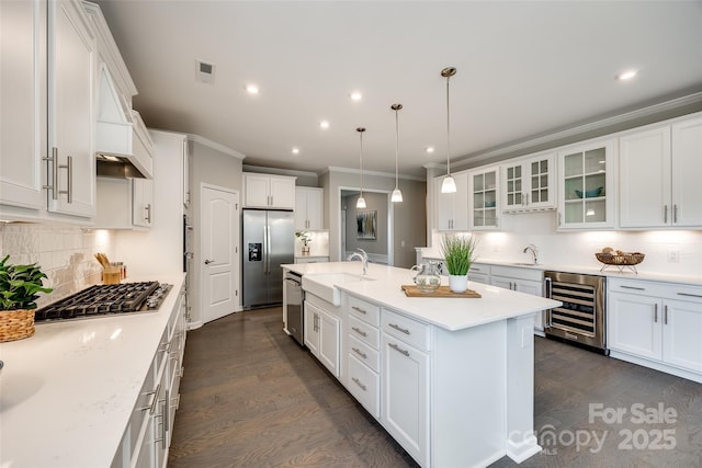 kitchen featuring a sink, beverage cooler, appliances with stainless steel finishes, and dark wood-style flooring