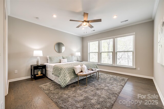 bedroom with ornamental molding, dark wood-style floors, baseboards, and visible vents