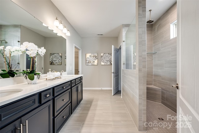 full bathroom featuring double vanity, visible vents, a walk in shower, and a sink