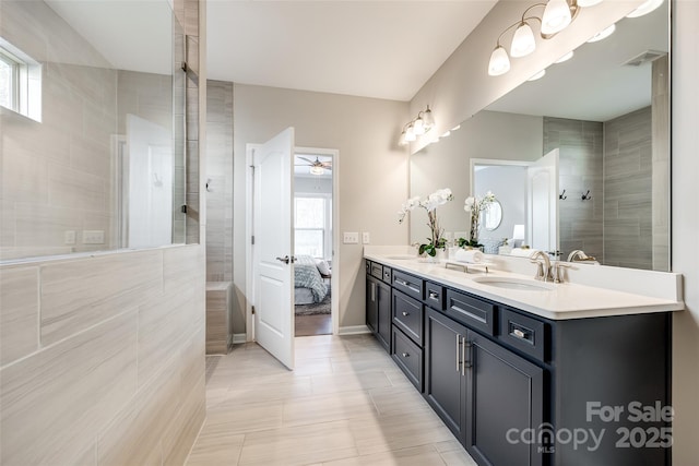 full bathroom featuring ensuite bath, ceiling fan, a sink, and walk in shower