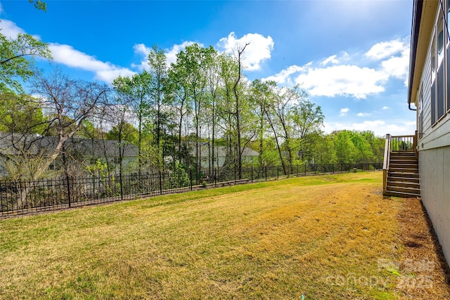 view of yard with fence and stairs