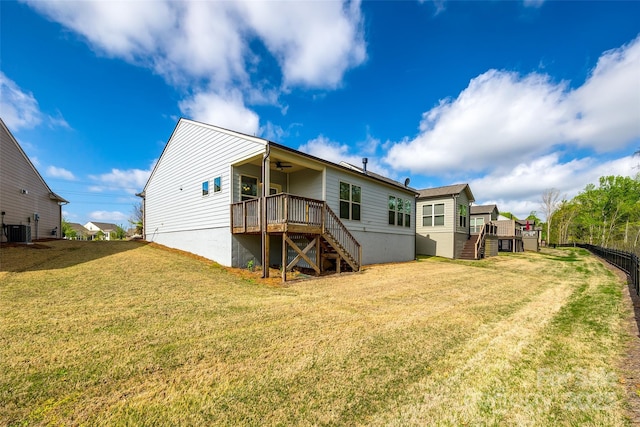 back of house with cooling unit, stairway, a wooden deck, a ceiling fan, and a lawn