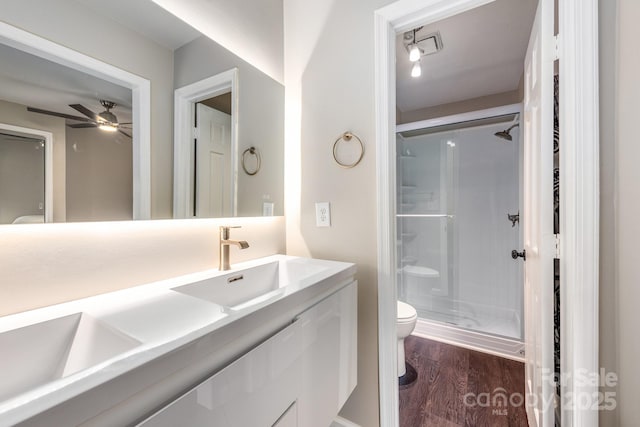 8308 Knights Bridge Rd, Charlotte, NC 28210 - bathroom featuring toilet, a stall shower, a ceiling fan, wood finished floors, and vanity