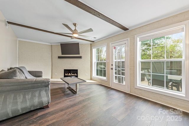 8308 Knights Bridge Rd, Charlotte, NC 28210 - living room featuring brick wall, ceiling fan, beamed ceiling, a brick fireplace, and dark wood-type flooring