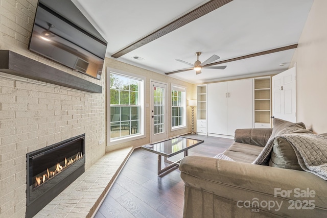 8308 Knights Bridge Rd, Charlotte, NC 28210 - living room with wood finished floors, visible vents, a ceiling fan, a fireplace, and built in shelves