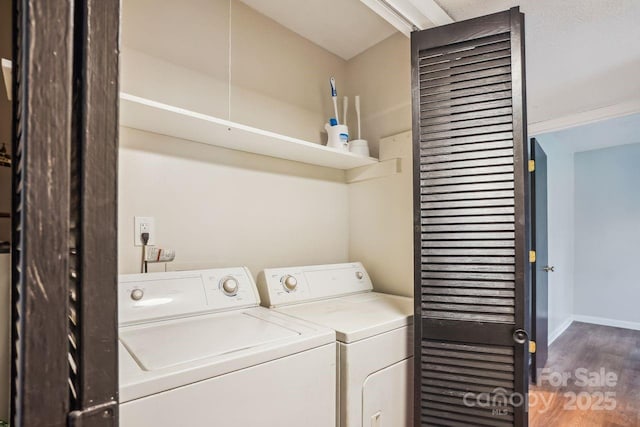 washroom featuring baseboards, separate washer and dryer, wood finished floors, and laundry area