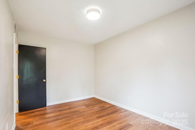 unfurnished room with baseboards and wood finished floors