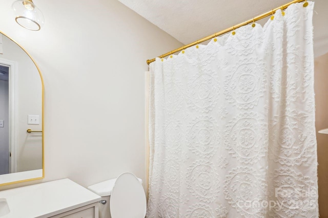 full bath with a shower with shower curtain, toilet, and vanity