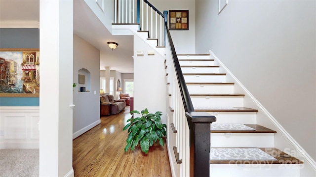 6108 Mcilwaine Rd, Huntersville, NC 28078 - stairway with baseboards, wood finished floors, a high ceiling, and ornate columns