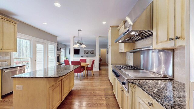 6108 Mcilwaine Rd, Huntersville, NC 28078 - kitchen featuring wall chimney range hood, light brown cabinets, a kitchen island, decorative backsplash, and appliances with stainless steel finishes