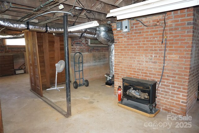 unfinished below grade area featuring a wood stove and brick wall