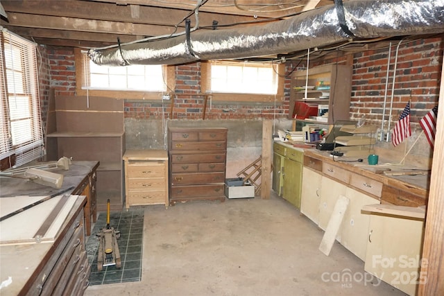 basement featuring a healthy amount of sunlight and brick wall