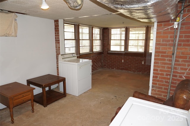below grade area with washer / clothes dryer and brick wall