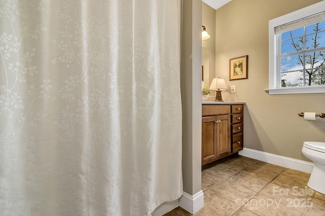 bathroom featuring tile patterned floors, vanity, baseboards, and toilet