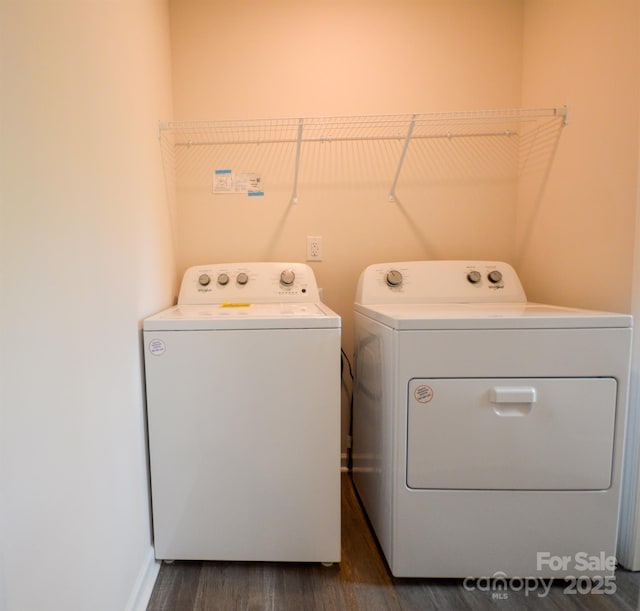 washroom featuring washing machine and dryer, baseboards, laundry area, and dark wood finished floors