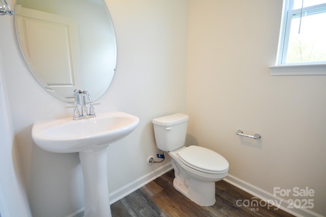 bathroom with wood finished floors, toilet, and baseboards