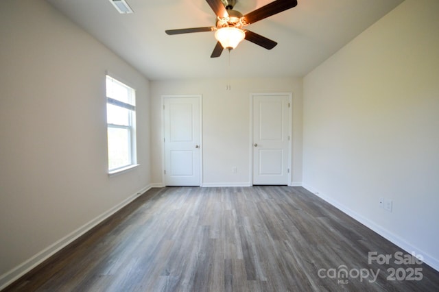 unfurnished bedroom with ceiling fan, baseboards, and dark wood-style flooring