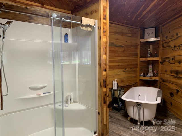 bathroom with wood ceiling, a freestanding tub, a shower stall, wood walls, and wood finished floors