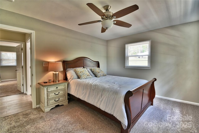 carpeted bedroom with ceiling fan and baseboards
