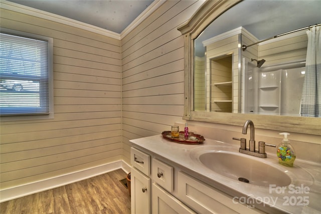 bathroom featuring a shower with shower curtain, wooden walls, wood finished floors, and vanity
