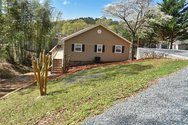 view of home's exterior with fence, stairs, a yard, and central AC unit