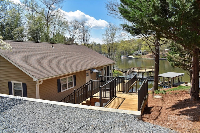 exterior space featuring a shingled roof and a water view