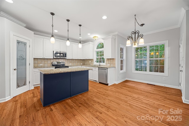 206 Coburn Ct, Fort Mill, SC 29715 - kitchen featuring appliances with stainless steel finishes, white cabinets, a chandelier, backsplash, and crown molding