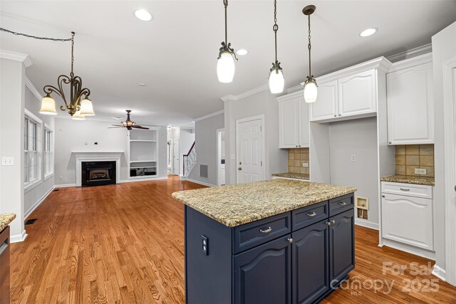 206 Coburn Ct, Fort Mill, SC 29715 - kitchen featuring a ceiling fan, white cabinets, crown molding, blue cabinetry, and light wood-type flooring