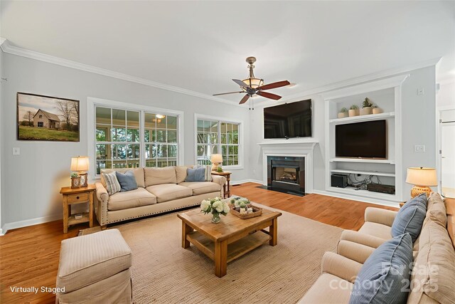 206 Coburn Ct, Fort Mill, SC 29715 - living room with ornamental molding, a ceiling fan, wood finished floors, built in shelves, and plenty of natural light