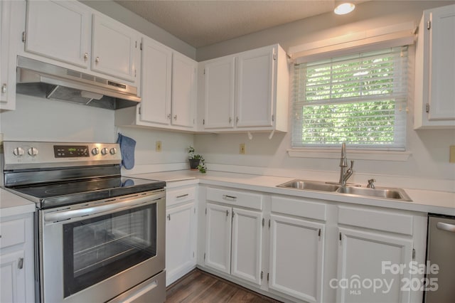 kitchen with light countertops, a sink, white cabinetry, appliances with stainless steel finishes, and under cabinet range hood