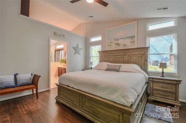 bedroom featuring lofted ceiling, dark wood-style flooring, baseboards, connected bathroom, and visible vents