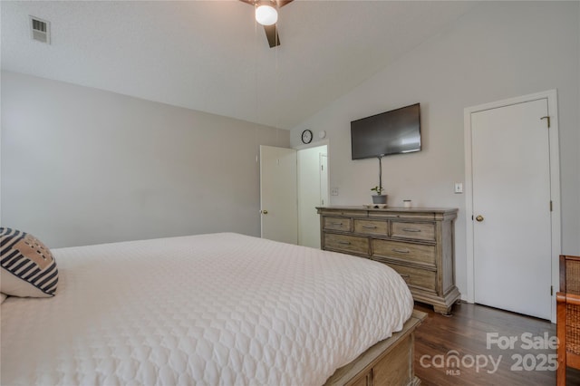 bedroom featuring dark wood-type flooring, visible vents, vaulted ceiling, and a ceiling fan