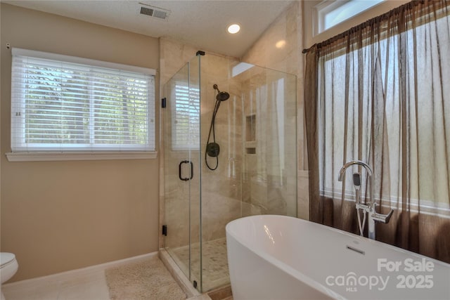 bathroom featuring baseboards, a shower stall, tile patterned floors, visible vents, and a freestanding bath