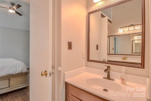 ensuite bathroom featuring vanity, wood finished floors, ceiling fan, and ensuite bath