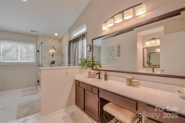 bathroom with visible vents, double vanity, lofted ceiling, a sink, and a stall shower