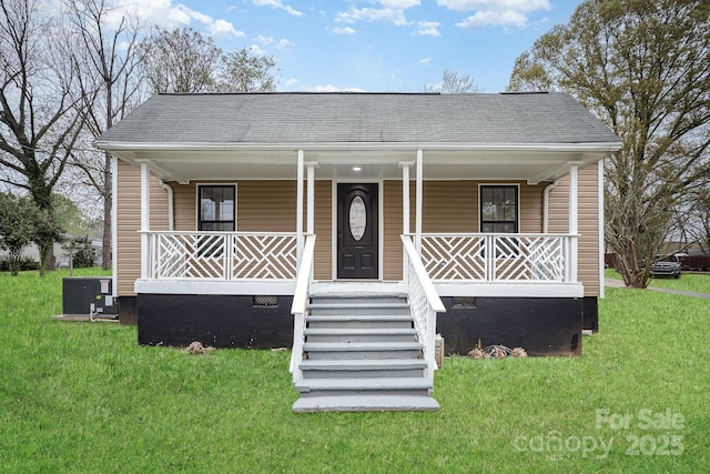 bungalow-style home with crawl space, covered porch, a front lawn, a shingled roof, and central AC unit