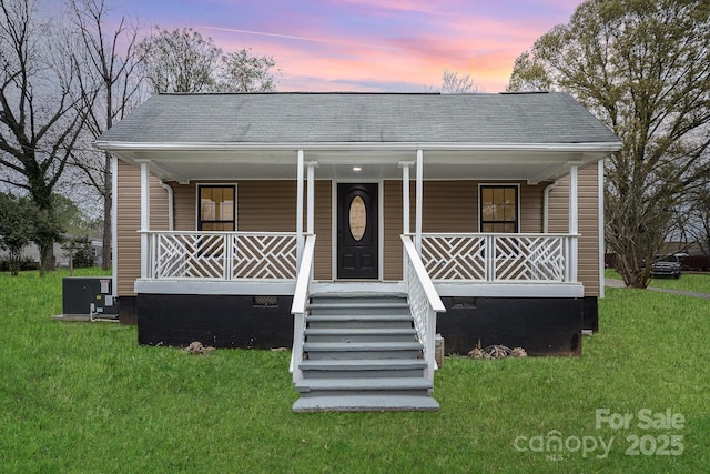 308 Birch St, Lowell, NC 28098 - view of front of house featuring a porch, central air condition unit, a shingled roof, and a lawn