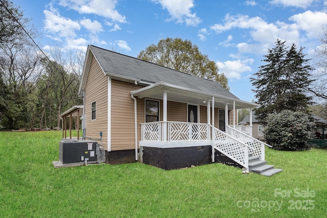 308 Birch St, Lowell, NC 28098 - view of front of house featuring covered porch, central AC, a front lawn, and roof with shingles