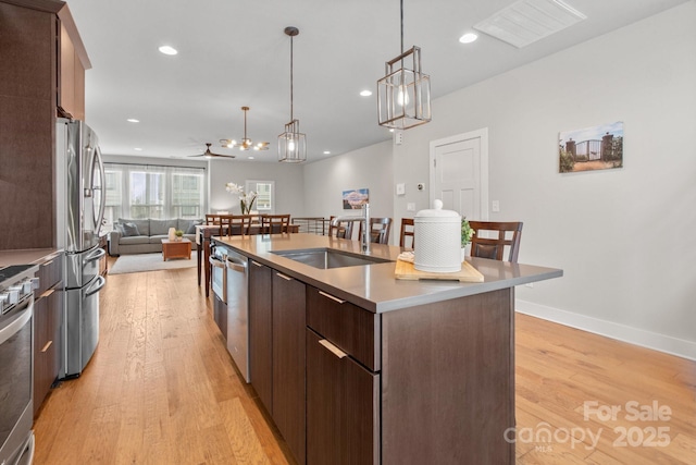 324 Uptown W Dr, Charlotte, NC 28208 - kitchen featuring appliances with stainless steel finishes, open floor plan, a kitchen island with sink, visible vents, and light wood-style floors