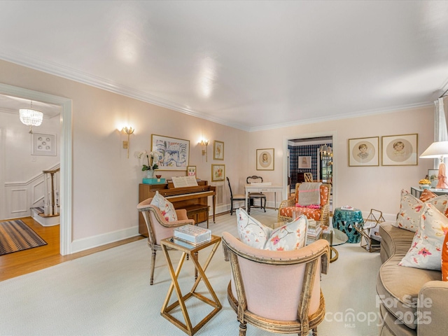 living area with baseboards, light wood-style floors, and ornamental molding