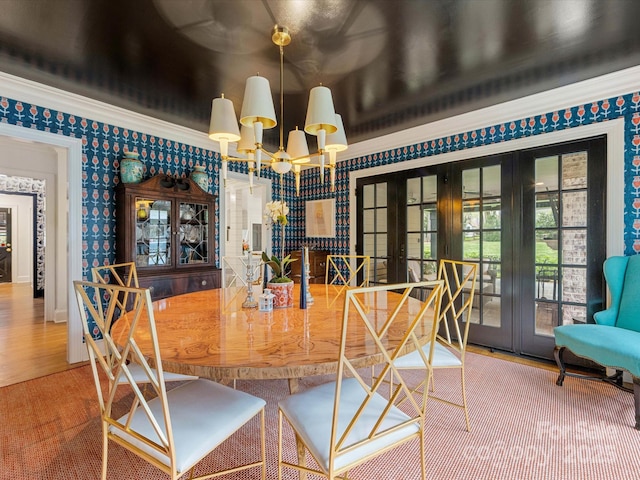 dining space featuring wallpapered walls, french doors, a notable chandelier, and wood finished floors