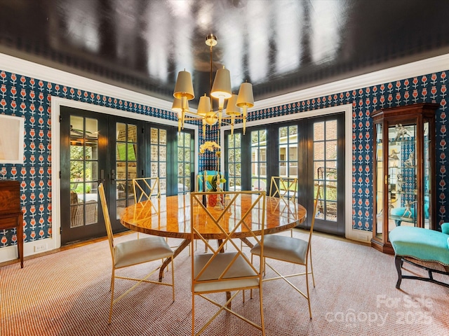 unfurnished dining area with an inviting chandelier, wallpapered walls, french doors, and a wealth of natural light