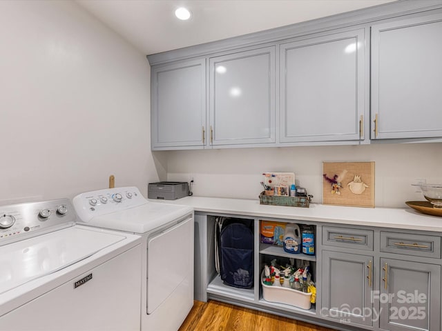 clothes washing area with washing machine and clothes dryer, cabinet space, recessed lighting, and light wood finished floors