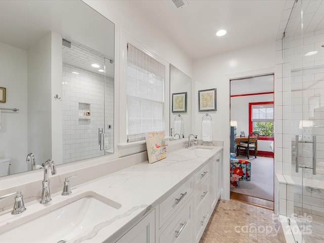 full bathroom featuring a shower stall, double vanity, recessed lighting, and a sink