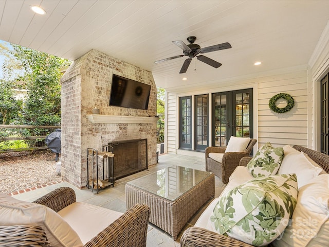 view of patio with an outdoor living space with a fireplace, fence, french doors, and ceiling fan